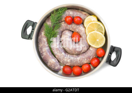 In a deep frying pan lies home cooked hot pork sausage, tomatoes, greens, slices of lemon. Presented on a white background. Stock Photo
