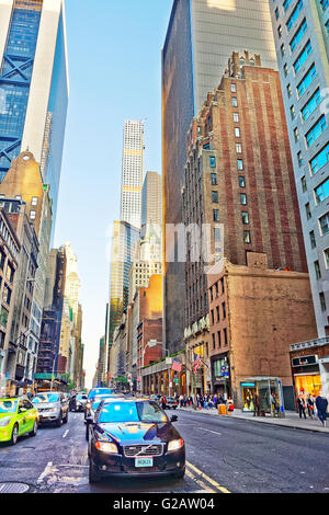 New York, USA - May 6, 2015: Intersection of Avenue of the Americas, or Sixth Avenue, and West 57th Street in Midtown Manhattan. 432 Park Avenue Building on the background. Tourists in the street Stock Photo