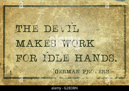 The devil makes work for idle hands - ancient German proverb printed on grunge vintage cardboard Stock Photo
