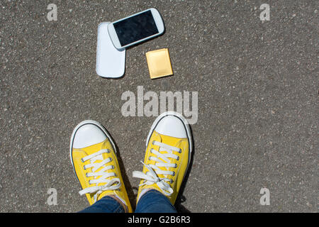 Disassembled smartphone on the ground in front of person. First person point of view Stock Photo