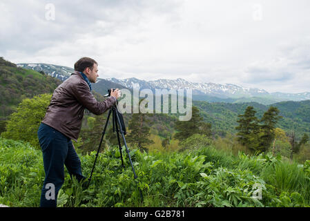 Nature photographer taking photos in the mountains Stock Photo
