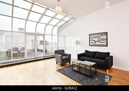 Conversion of Dach or Loft Space in Reichenberger Strasse, Kreuzberg. Spacious modern living area with minimal furniture. Curved ceiling to floor windows. Stock Photo