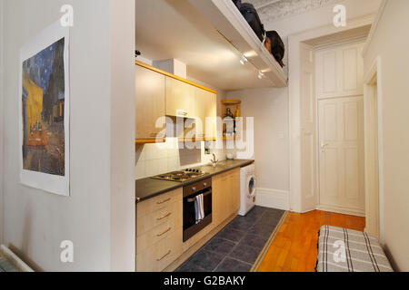 Pembridge Square, Notting Hill. View of a small, old fashioned kitchens. Wood cabinets and white washing machine. Stock Photo