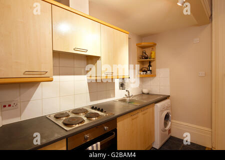 Pembridge Square, Notting Hill. View of an older, typical kitchen. Wood cabinets and white washing machine. Stock Photo