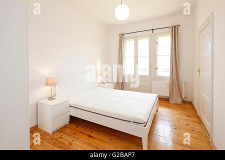 Wisbyer Strasse 59. Modern bedroom with minimal furnishing and large windows. Stock Photo
