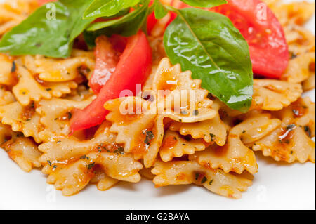Italian pasta farfalle butterfly bow-tie with tomato basil sauce over white rustic wood table Stock Photo