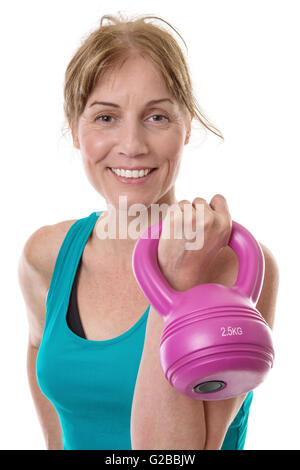 Close up shot of a fitness model holding a pink kettlebell in her left hand, isolated on white Stock Photo