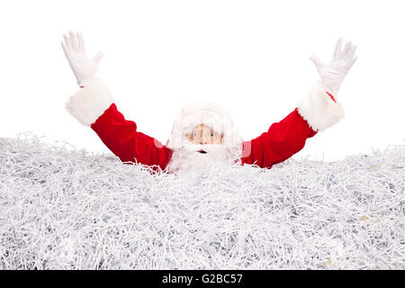 Studio shot of Santa Claus drowning in a pile of shredded paper isolated on white background Stock Photo