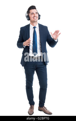 Full body of handsome young businessman listening music and dancing feeling relaxed isolated on white background Stock Photo