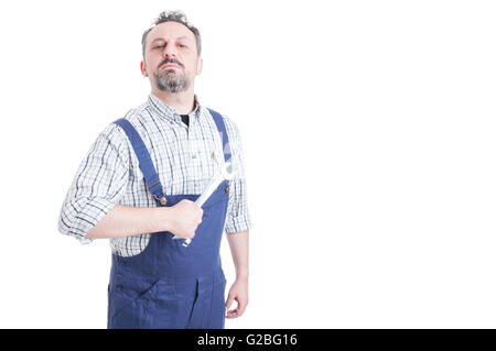 Portrait of attractive male mechanic in blue overalls holding wrench acting like a boos with copyspace isolated on white Stock Photo