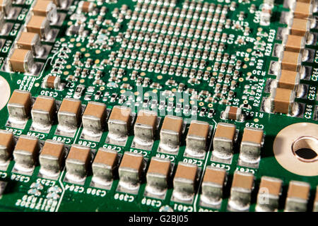 Small electronic components on green circuit board macro closeup Stock Photo