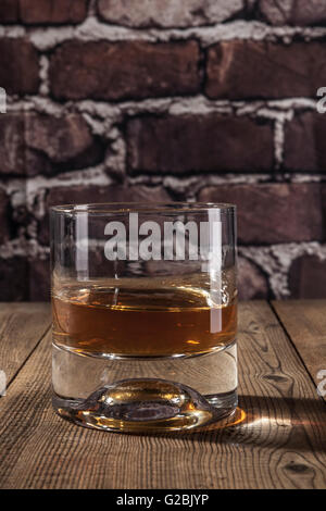 Glass of alcohol on brown wood table Stock Photo