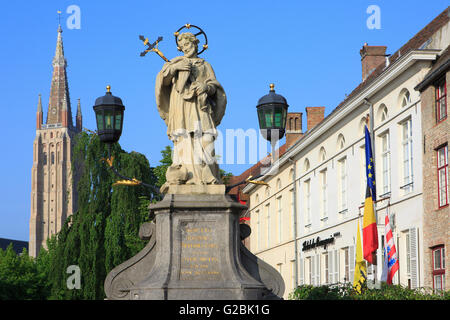 Statue of John of Nepomuk (1345-1393) near the Church of Our Lady (13th-15th centuries) in Bruges, Belgium Stock Photo