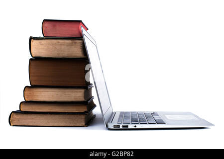 Old Books Pile with silver laptop isolated on white background Stock Photo