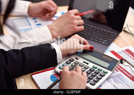co worker considers on the calculator profit Stock Photo