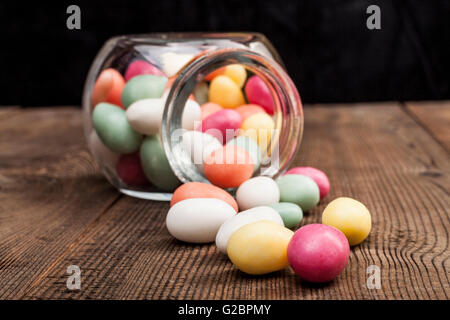 Spilled From Jar Color Candy on Wood Table Stock Photo