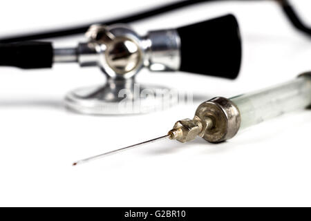 Glass Syringe With Black Old Stethoscope on White Background Stock Photo