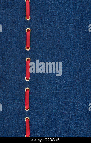 Fashionable background red satin ribbon inserted in denim, with space for your creativity Stock Photo