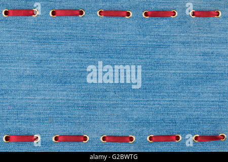 Fashionable background red satin ribbon inserted in denim, with space for your creativity Stock Photo
