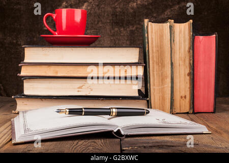 Old Books on Wood Table With Coffee and Open Notebook Stock Photo