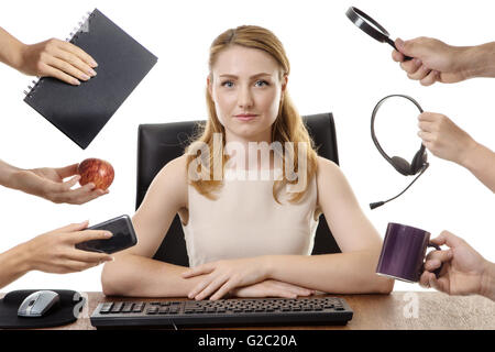 businesswoman at her desk looking at you,  surrounded by many hands with different objects in each hand Stock Photo