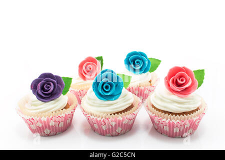Cupcakes decorated with roses on a white background. Stock Photo