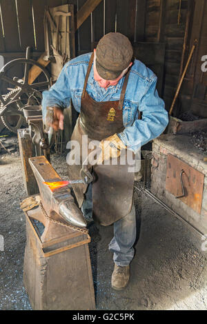 California, Coloma, Marshall Gold Discovery State Historic Park, blacksmith hammering knife blade on anvil Stock Photo