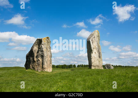A pair of standing stones, part of the huge stone circle in Avebury Wiltshire. Blue sky with fluffy clouds and lush green grass. Stock Photo