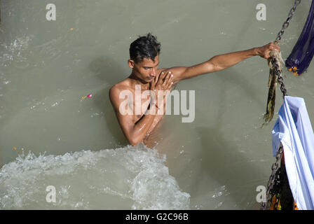 Hindu pilgrim taking a holy bath in the Ganges river, Har ki Paudi, Haridwar, Uttarakhand, India Stock Photo