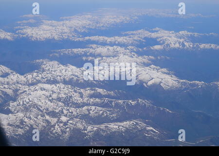 View of snow covered The Alps mountain range from airplane window Stock Photo