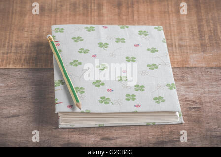 Closeup of handmade book and pencil on wooden background Stock Photo