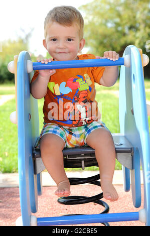 blond barefoot boy having fun with games in the park Stock Photo