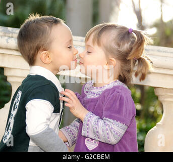 shy girl and boy kissing tenderly in the park Stock Photo