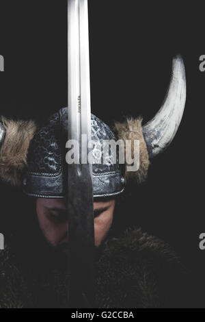 War, Viking warrior with iron sword and helmet with horns Stock Photo