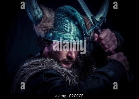 Terrified, Viking warrior with iron sword and helmet with horns Stock Photo