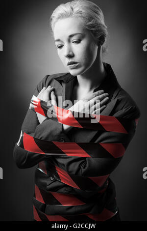 Business woman wrapped up in red tape Stock Photo