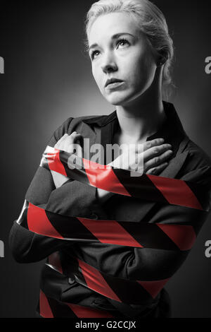 Business woman wrapped up in red tape Stock Photo