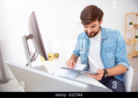Bearded man looking at his tablet Stock Photo