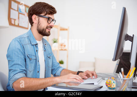 Glad man working on computer Stock Photo