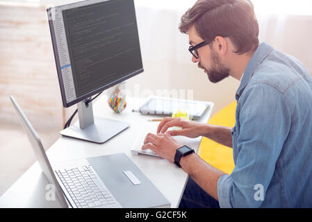 Man writing codes on computer Stock Photo