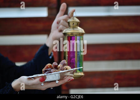 Emarati Arab woman holding dates plate and Ramadan Lamp, Dubai, United Arab Emirates. Stock Photo