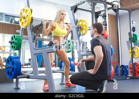 fitness woman and personal trainer in gym Stock Photo