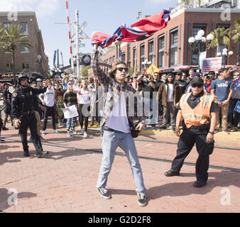 San Diego, California, USA. 27th May, 2016. A young man waves a Confederate flag over his head in front of the San Diego Convention Center on Friday afternoon. --- Donald Trump campaigned in San Diego at the San Diego Convention Center on Friday drawing several thousand supporters and protestors. The San Diego Police Department designated two freedom of speech areas for Trump supporters and protestors. The Rally ended peacefully although as Trump supporters and protesters met on the street outside the convention center several fights broke out bringing in police to disperse the crowd after d Stock Photo