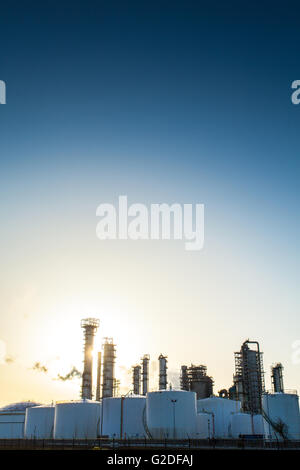 Cloudless day with sun behind a series of white storage tanks and chemical production complex Netherlands Rotterdam Botlek area Stock Photo