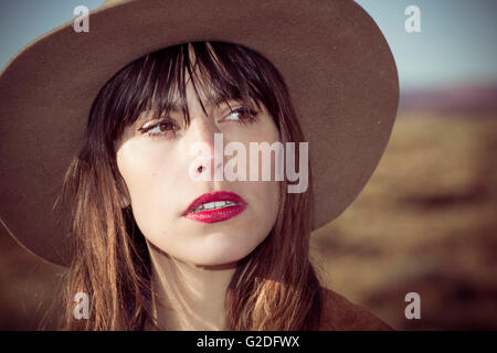 Portrait of Young Adult Woman in Cowboy Hat and Red Lipstick Stock Photo