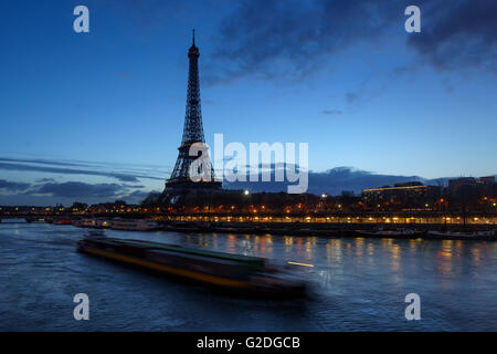 Eiffel Tower and Seine River at dawn with a passing barge. Port de Suffren, Paris, 75015, France Stock Photo