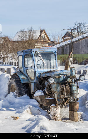 old abandoned rusty tractor without wheels in the countryside Stock Photo