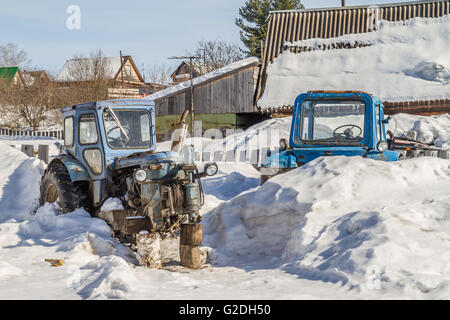 old abandoned rusty tractor without wheels in the countryside Stock Photo