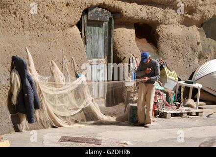 Man mending fishing nets, Ventotene harbour, Italy Stock Photo