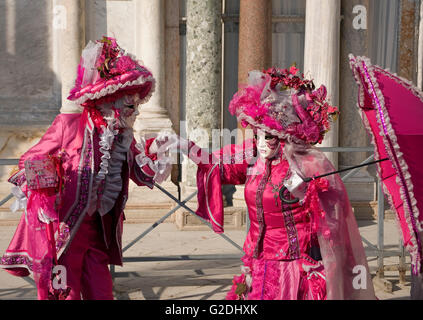 Venice Carnival: two elaborately-costumed carnevale revellers pose for the cameras in the Piazzetta San Marco, Venice, Italy Stock Photo
